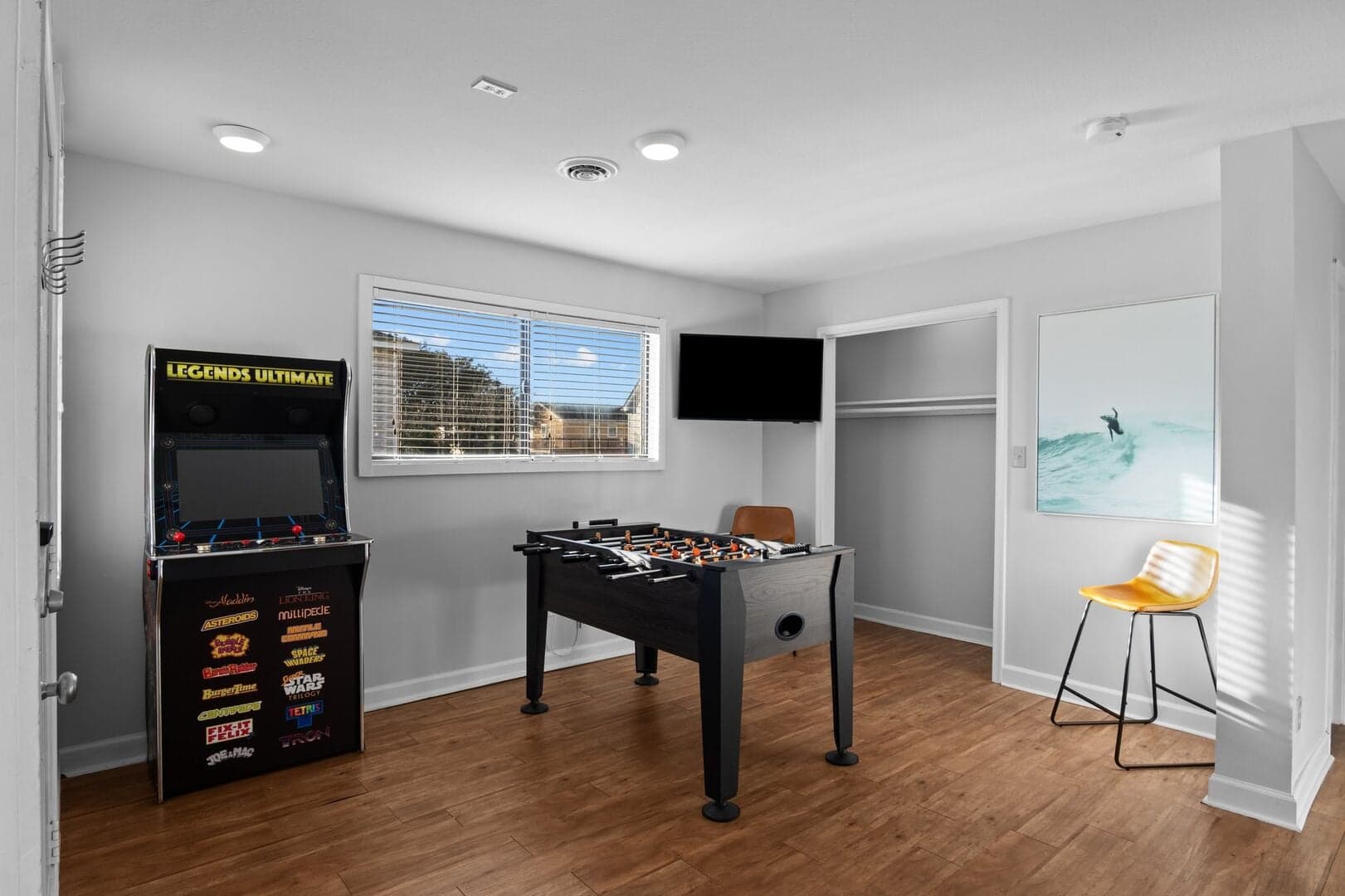 Rec room with foosball table, arcade game, and wall-mounted TV